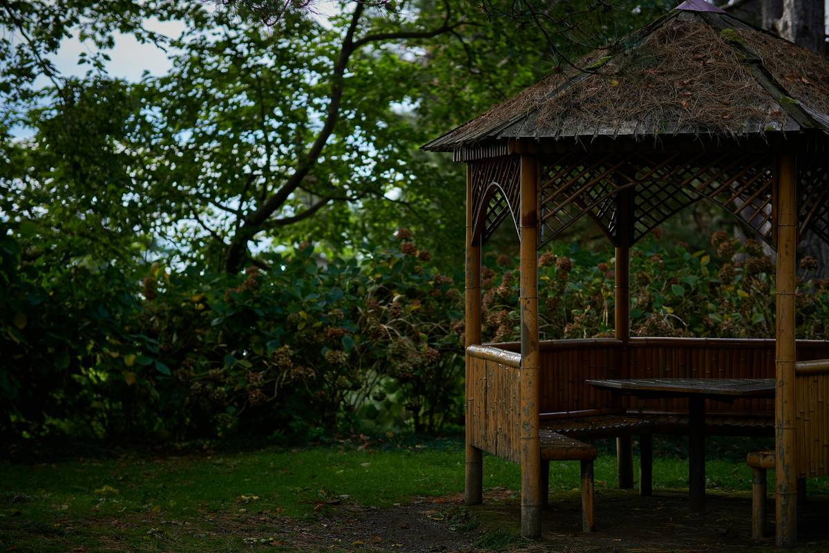 Teak wooden gazebo for garden with built-in bench seating and cushion accents